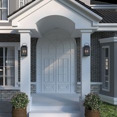 the front entrance to a house with two potted plants