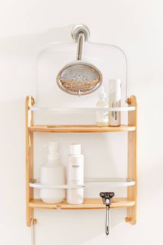 a bathroom shelf with soap, shampoo and lotion bottles on it next to a wall mounted faucet