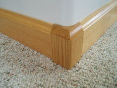 a close up of a bed frame on carpeted floor with white walls in the background