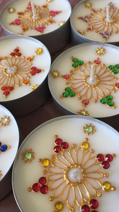 four white candles with colorful jewels on them