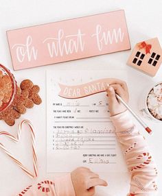 a baby is writing on a paper next to some candy canes and candies