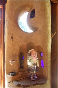 the inside of a house with a round window and small table in front of it