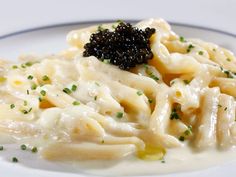 a white plate topped with macaroni and cheese covered in black cauliflower