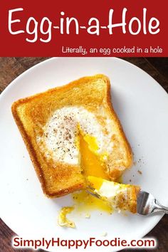 a piece of toast with an egg in it on a white plate next to a fork