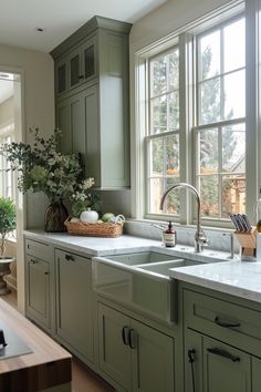 a kitchen filled with lots of green cabinets and counter top space next to a window