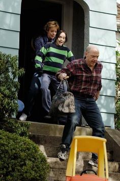 an older man sitting on the steps with two children