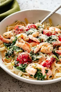 a white bowl filled with pasta and shrimp