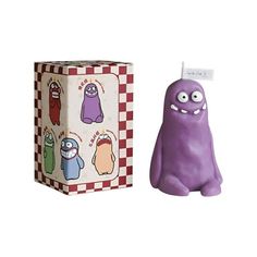 a purple toy sitting next to a box with stickers on it's side