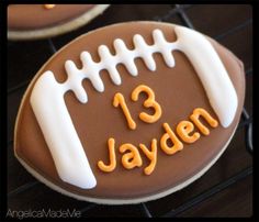 a decorated football cookie with the name 13 jayden on it