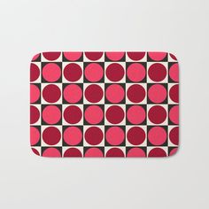 a bath mat with red and black circles on it