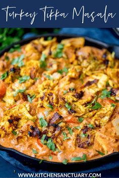 a pan filled with food sitting on top of a blue cloth covered table next to rice