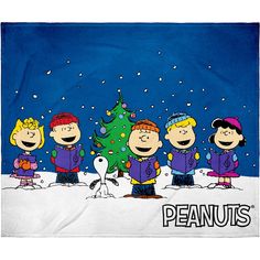 the peanuts gang standing in front of a christmas tree