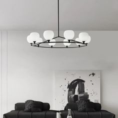 a black and white living room with two couches, a coffee table and a painting on the wall