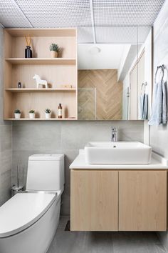 a bathroom with a toilet, sink and mirror