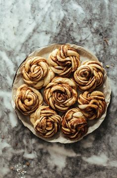 some cinnamon rolls are on a plate and ready to be eaten by someone in the kitchen