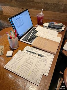 an open laptop computer sitting on top of a wooden table next to a cup of coffee