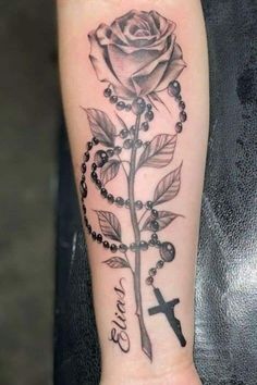 a rosary and rose tattoo on the wrist