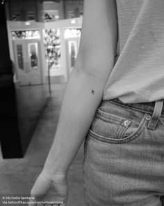 a person with a small tattoo on their left arm holding the hand of another person