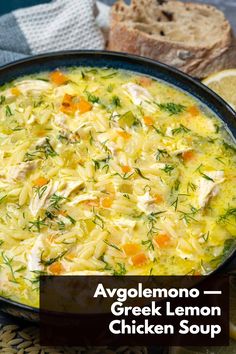 a bowl filled with chicken soup next to sliced lemons and bread on a table