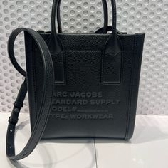 Marc Jacobs Small Size Supply Tote In Color Black. Some With Crossbody Strap Designer Black Bag With Embossed Logo, Evening Black Shoulder Bag With Embossed Logo, Classic Black Shoulder Bag With Engraved Logo, Designer Black Bag With Engraved Logo, Designer Black Bags With Engraved Logo, Black Designer Bag With Engraved Logo, Designer Black Shoulder Bag With Engraved Logo, Modern Black Shoulder Bag With Engraved Logo, Elegant Black Bag With Embossed Logo