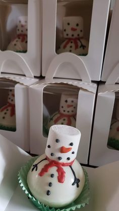 there is a snowman cupcake with frosting on it and some boxes in the background