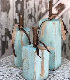 three small blue boxes with brown ribbons tied around them