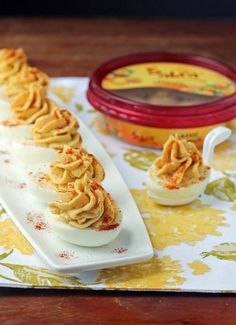 deviled eggs stuffed with cinnamon sit on a plate next to an ice cream container