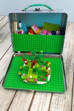 an open suitcase filled with legos on top of a wooden table