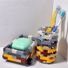 a toothbrush holder made out of legos and some other items on a table