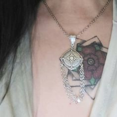 a close up of a person wearing a necklace with an owl on it's chest