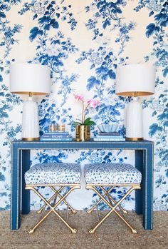 two blue and white chairs sitting next to a table with lamps on top of it