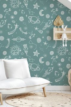 a white couch sitting in front of a green wall with space drawings on it's walls