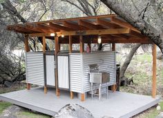 a small outdoor kitchen in the middle of some trees