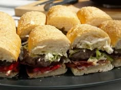 several sandwiches are arranged on a black plate