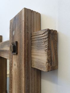 an old wooden door is hanging on the wall next to a white wall and a mirror