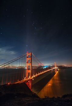 the golden gate bridge is lit up at night