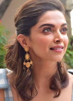 anusha ghosar in blue dress looking at the camera with her eyes closed