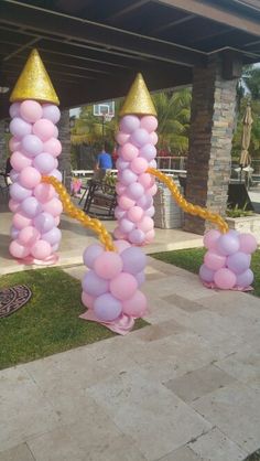 some pink and gold balloons are in the grass