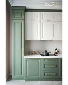 a kitchen with green cabinets and white counter tops