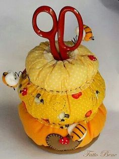 an orange and yellow stuffed animal sitting on top of a pile of other items in front of a white background