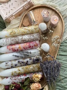 an assortment of candles and flowers on a tray