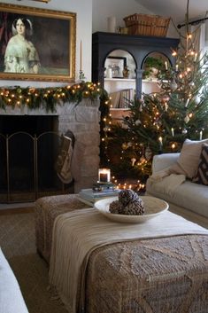 a living room filled with furniture and a fire place next to a christmas tree in front of a fireplace