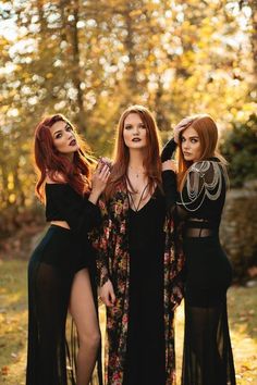 three women in long dresses standing next to each other