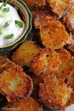 fried potatoes with sour cream and green onions in a bowl on the side, ready to be eaten