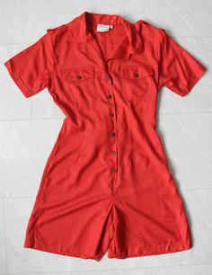 "80s Vintage red overalls short shorts one piece romper jumpsuit playsuit. Buttons on front, chest pockets, back ties, shoulder tabs, no lining. Material is viscose. Tag: WOMAN Collection Size 34 Fits like size S Measured laying flat (double for circumference): 32.5'' / 83 cm long 18'' / 46 cm bust armpit to armpit 15.5'' / 39 cm waist 20'' / 51 cm hips 15.5\" / 40 cm shoulders seam to seam 8.5\" / 21 cm sleeve length 6.5'' / 16 cm inseam There are two stains on the back, please see the last pic Short Jean Romper Outfit, Summer Short Length Jumpsuits And Rompers With Pockets, Fitted Shortalls For Summer, Fitted Summer Shortalls, Red Short Sleeve Jumpsuits And Rompers With Pockets, Red Jumpsuits And Rompers For Summer Workwear, Red Jumpsuits And Rompers With Pockets, Summer Short Jumpsuits And Rompers With Pockets, Retro Fitted Summer Overalls