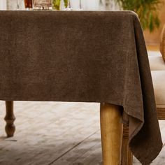 an orange tabby cat sitting on top of a wooden chair next to a table