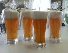 three glasses filled with beer sitting on top of a table next to a bag full of wine