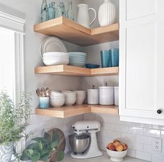 the shelves in the kitchen are filled with dishes