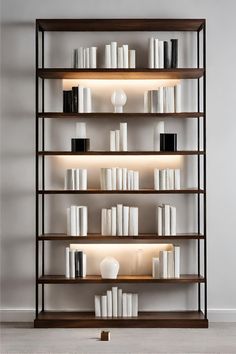 a bookshelf filled with lots of white and black items next to a wall