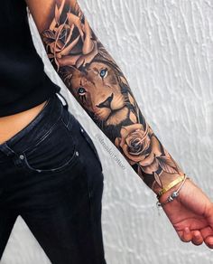 a woman with a lion tattoo on her arm holding the hand of a man in jeans